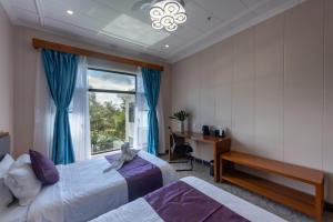 CatagnanSiargao Seasky Resort的一间卧室设有两张床、一张桌子和一个窗口。