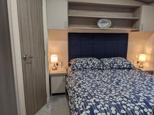 Saint HelensModern 2 Bedroom Mobile home with parking on St Helens Coastal Resort Isle of Wight的一间卧室配有一张床和一个蓝色床头板