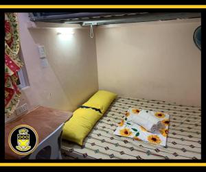 杜马格特White Knights Dumaguete的小房间设有一张带黄色枕头的床