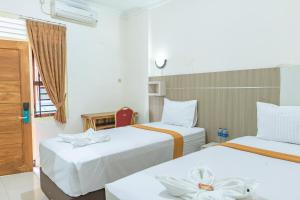 日惹美图玛林博瑞丽旅馆的酒店客房设有两张床和窗户。