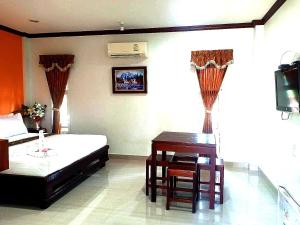 夜功府Capital O 75415 Nanthachart Riverview Resort的一间卧室配有书桌、一张床和一张桌子