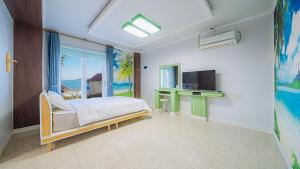 巨济Geojerowa Pension的一间卧室设有一张床、一台电视和一个窗口。