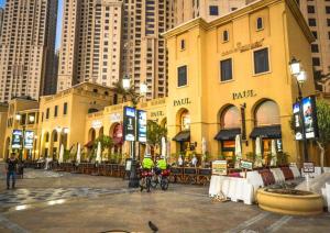 迪拜Luxury JBR · 2BR · 5* Beach Resorts Access!的两人骑车在大楼前