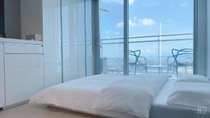 仁川市Shine residence的卧室设有白色的床和大窗户