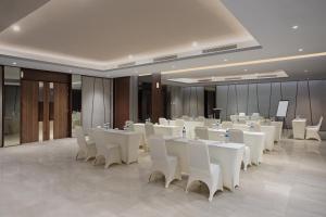 巴淡岛中心Hotel Santika Batam的宴会厅配有白色的桌子和白色的椅子