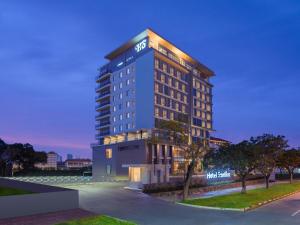 巴淡岛中心Hotel Santika Batam的夜间酒店建筑的 ⁇ 染