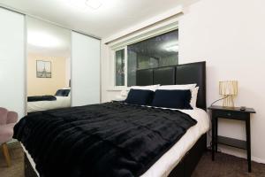 布拉姆霍普West Park House的卧室设有一张大型黑色床和一扇窗户。