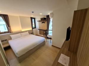 曼谷Thana Wisut Hotel - SHA Plus的一间卧室配有一张床和一台电视
