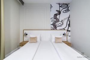 萨拉热窝Hotel Sahat的卧室配有带枕头的大型白色床