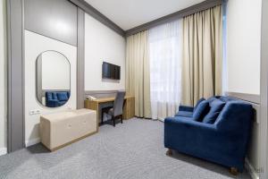 萨拉热窝Hotel Sahat的客厅配有蓝椅和镜子
