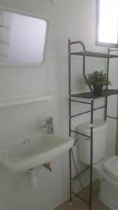 曼谷OYO 75416 Rama3 Sunrise Hostel的一间带水槽、镜子和卫生间的浴室