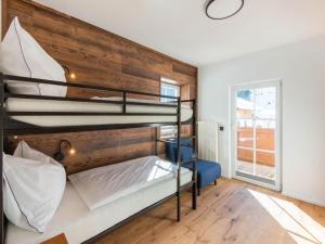 霍赫克尼希山麓丁滕Leni`s Mountain Appartements的一间卧室设有两张双层床和木墙