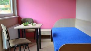 DaugaiPoilsio bazė Draugai的配有桌椅和粉红色墙壁的客房