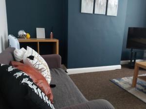 考文垂Comfy 4 bed home away from home的客厅拥有蓝色的墙壁和沙发