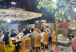 芽庄Garden House Nha Trang的一群坐在餐厅桌子上的人