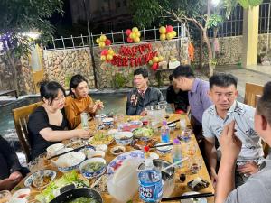 芽庄Garden House Nha Trang的一群坐在桌子旁吃食物的人