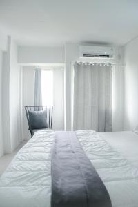 加拉旺Kia Servised Apartmen at Grand Sentraland Karawang的白色的卧室设有床和窗户
