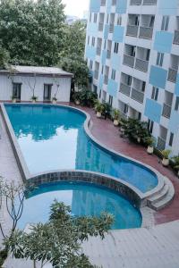 加拉旺Kia Servised Apartmen at Grand Sentraland Karawang的大楼前的游泳池