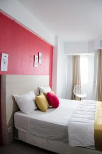 加拉旺Kia Servised Apartmen at Grand Sentraland Karawang的一间卧室配有红色和黄色枕头的床