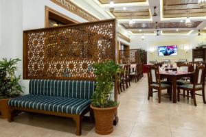 迪亚尼海滩迪亚尼普莱德酒店的餐厅设有长凳和桌椅