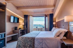 圣马力诺La Grotta Hotel的酒店客房设有一张床和一个大窗户