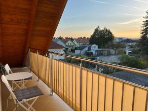 维也纳附近格拉斯多夫Vienna's Nature Corner - charming rooftop family apartment的设有一个配有桌椅并享有美景的阳台。