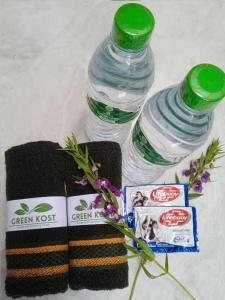 SintangGreenKOST的毛巾和鲜花旁的两瓶水