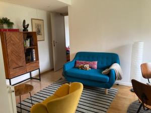 巴黎Vue sur jardin, 3 pièces的客厅配有蓝色的沙发和两把椅子