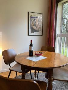 巴黎Vue sur jardin, 3 pièces的一张桌子,上面放着一瓶葡萄酒和一碗