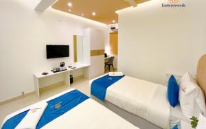 班加罗尔Easternwoods Hotels的酒店客房配有两张床和一张书桌