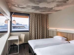 梅济约ibis Lyon Est Meyzieu的酒店客房设有两张床和窗户。
