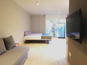 马塔罗Mazi Apartments Suite的客房设有床、沙发和电视。