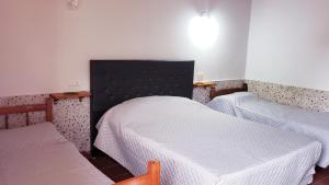 卡法亚特Portal de las Viñas的一间卧室配有两张带白色床单的床
