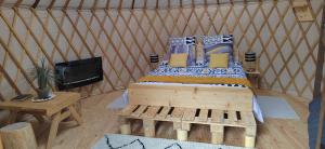 弗瑞兰Yourte des Verts Bois的蒙古包内一间卧室,配有一张木床