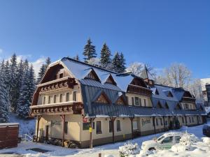 贝德日霍夫Wellness Penzion Jarmilka的一座大建筑,地面上积雪