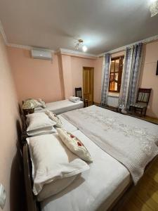 布哈拉Hotel Al Mansur的一间卧室设有两张床和窗户。
