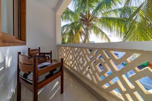 迪亚尼海滩迪亚尼普莱德酒店的阳台配有两把椅子和棕榈树