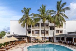 迪亚尼海滩迪亚尼普莱德酒店的一座拥有游泳池和棕榈树的酒店