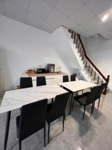 茄萣路科民宿的一间设有白色桌椅的用餐室和楼梯