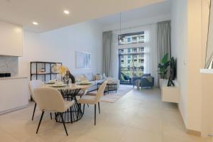 迪拜HiGuests - Charming Modern Apartment Close To The Souk in MJL的厨房以及带桌椅的起居室。