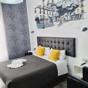 马德里劳里亚旅馆的一间卧室配有一张带黄色枕头的大床