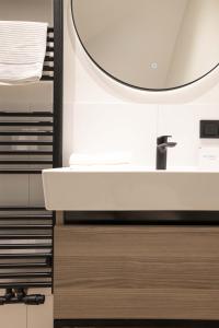 斯海弗宁恩Four Star Apartments - Badhuisstraat 6的浴室设有白色水槽和镜子
