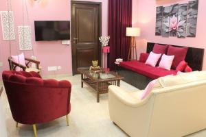 新德里Luxurious modern 2BHK prime location Delhi (13)的客厅配有红色的沙发和椅子