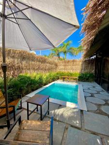 罗纳瓦拉ROOM with PRIVATE POOL BY CANVAS VILLA LONAVLA的一个带遮阳伞和桌椅的游泳池