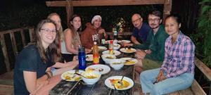 邦隆Ratanakiri Homestay & Jungle Trek的一群坐在桌子旁吃食物的人