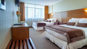 康塞普西翁HOTEL EL DORADO的酒店客房带两张床和长凳
