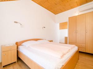 科洛塞普Holiday Home Macus的一间卧室配有一张大床和一个木制橱柜