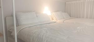 大邱Blooming Guest House的白色的床、白色床单和枕头
