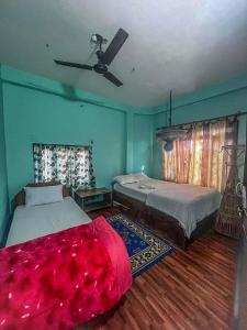 索拉哈Tiger Corner Inn Homestay的一间卧室配有两张床和吊扇