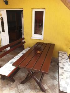 赫维兹Vilmos Pince Fogadó的一张坐在黄色墙前的木桌
